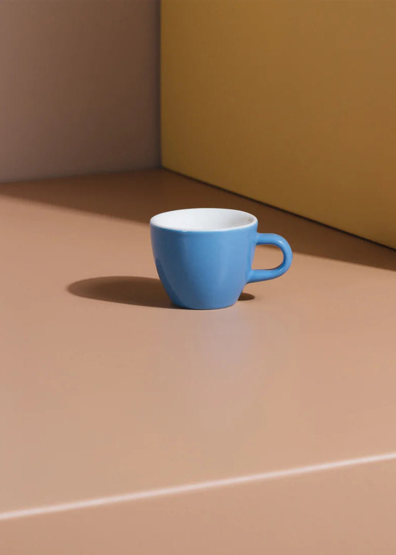 Blue cup on a neutral surface with a neutral background