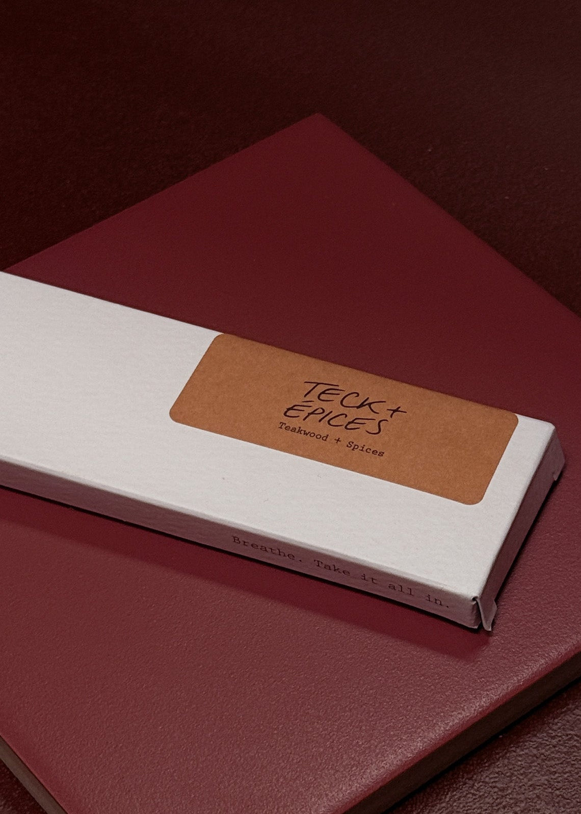 White incense box featuring an orange label on a red surface