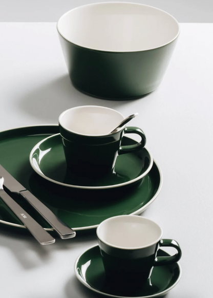 Green and white ceramic tableware set on a white surface