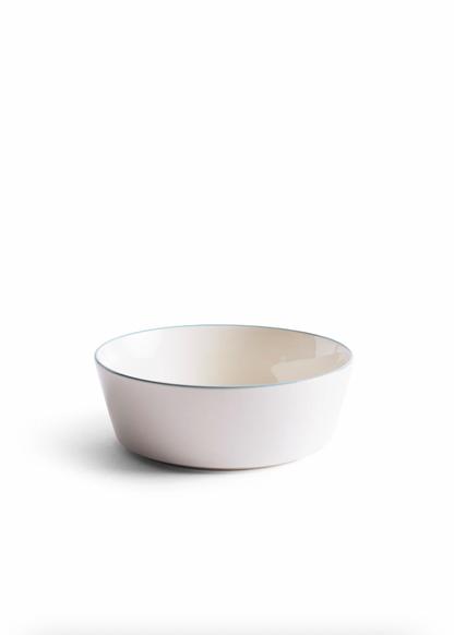 White ceramic bowl with a thin blue rim on a white background