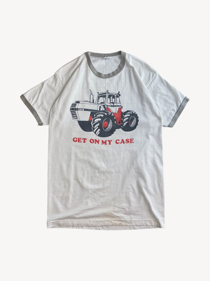 White t-shirt with a graphic of a tractor and text 'GET ON MY CASE' on a white background