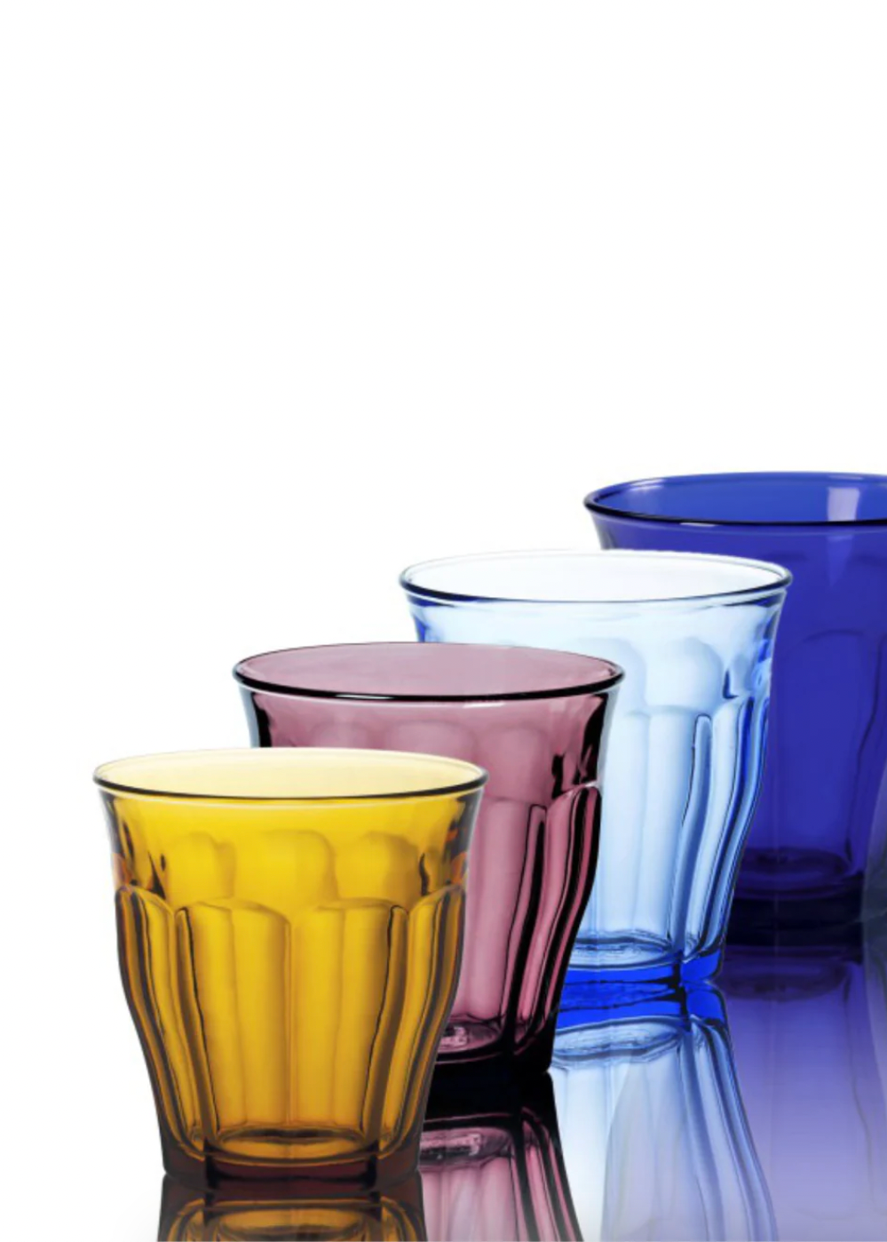 Set of four colorful glass tumblers on a reflective surface with a white background