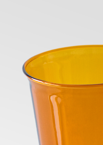 Close-up of a yellow glass on a light gray background