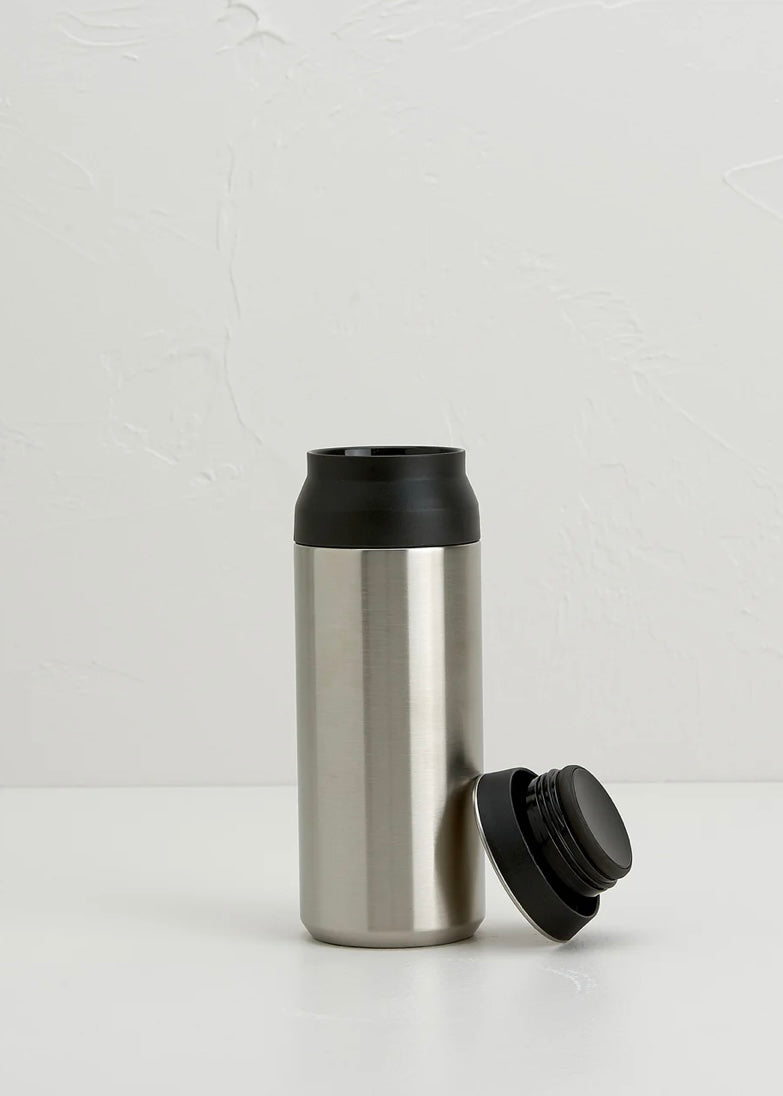 Stainless steel tumbler with black lid on a white background