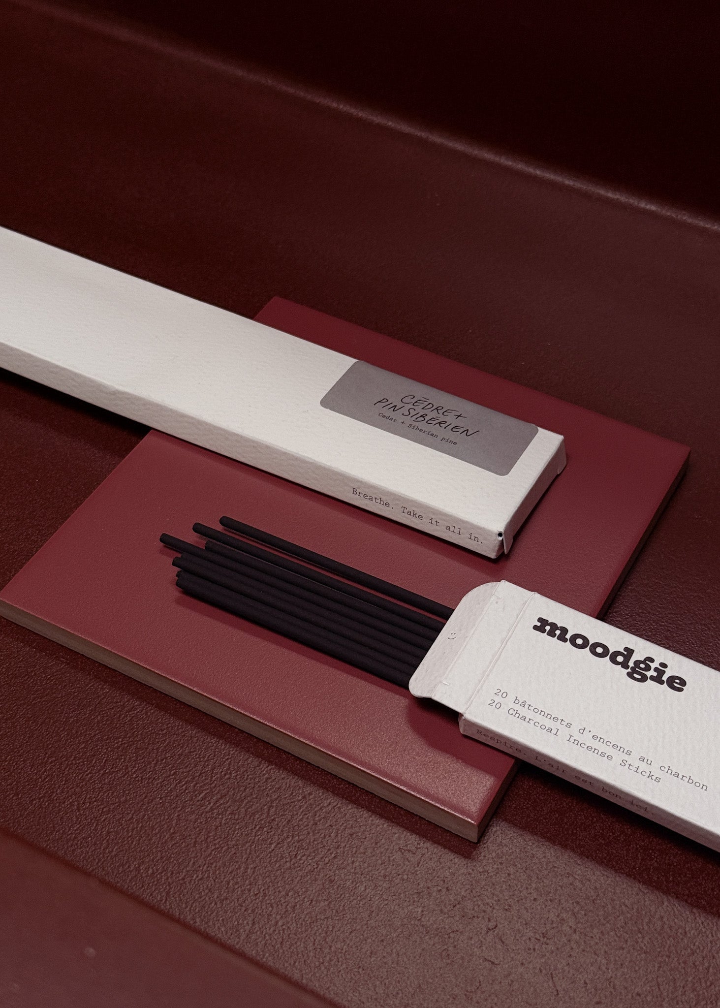 Moodgie incense sticks with packaging on a maroon surface