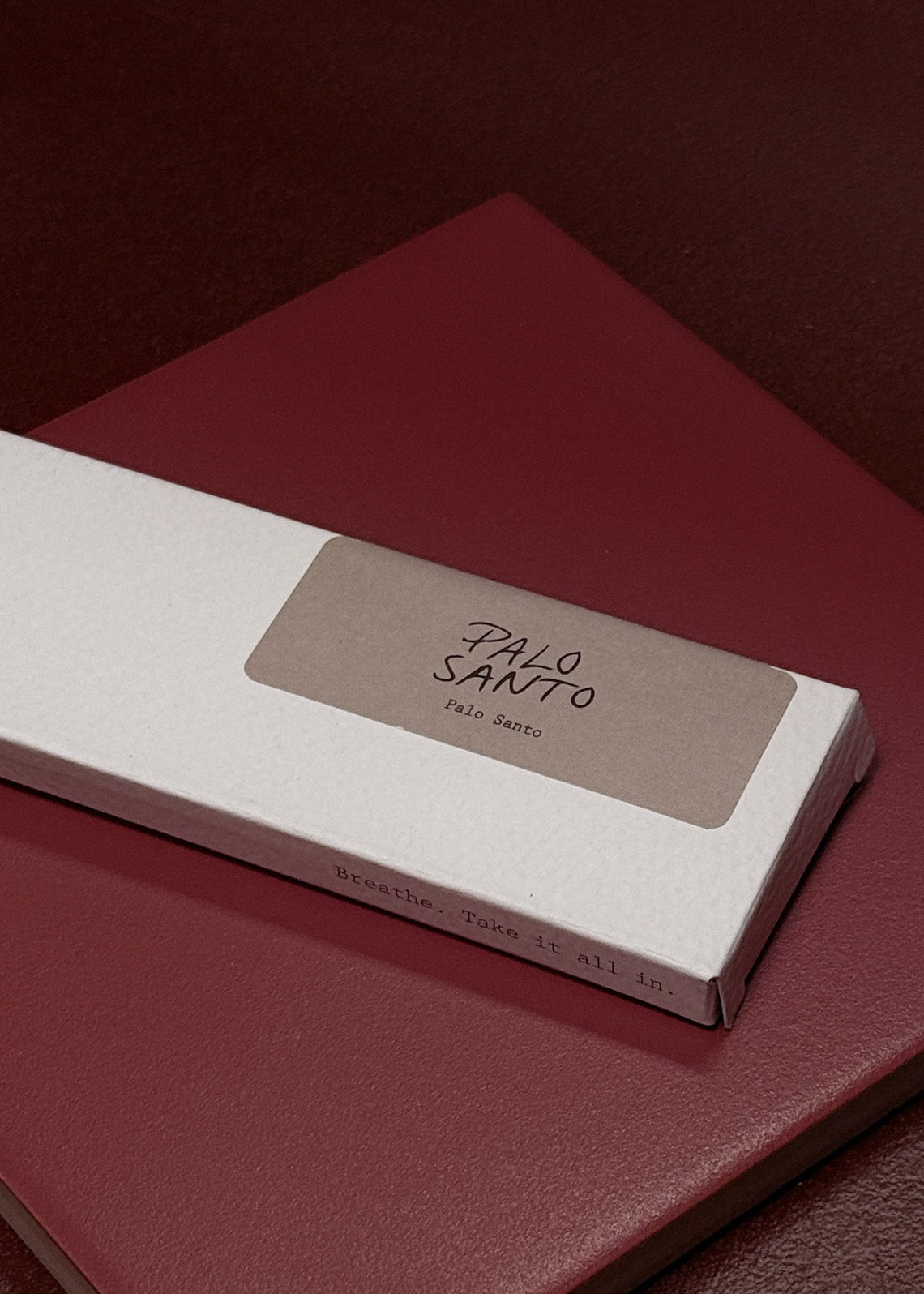 Small white box labeled 'Palo Santo' on a red surface