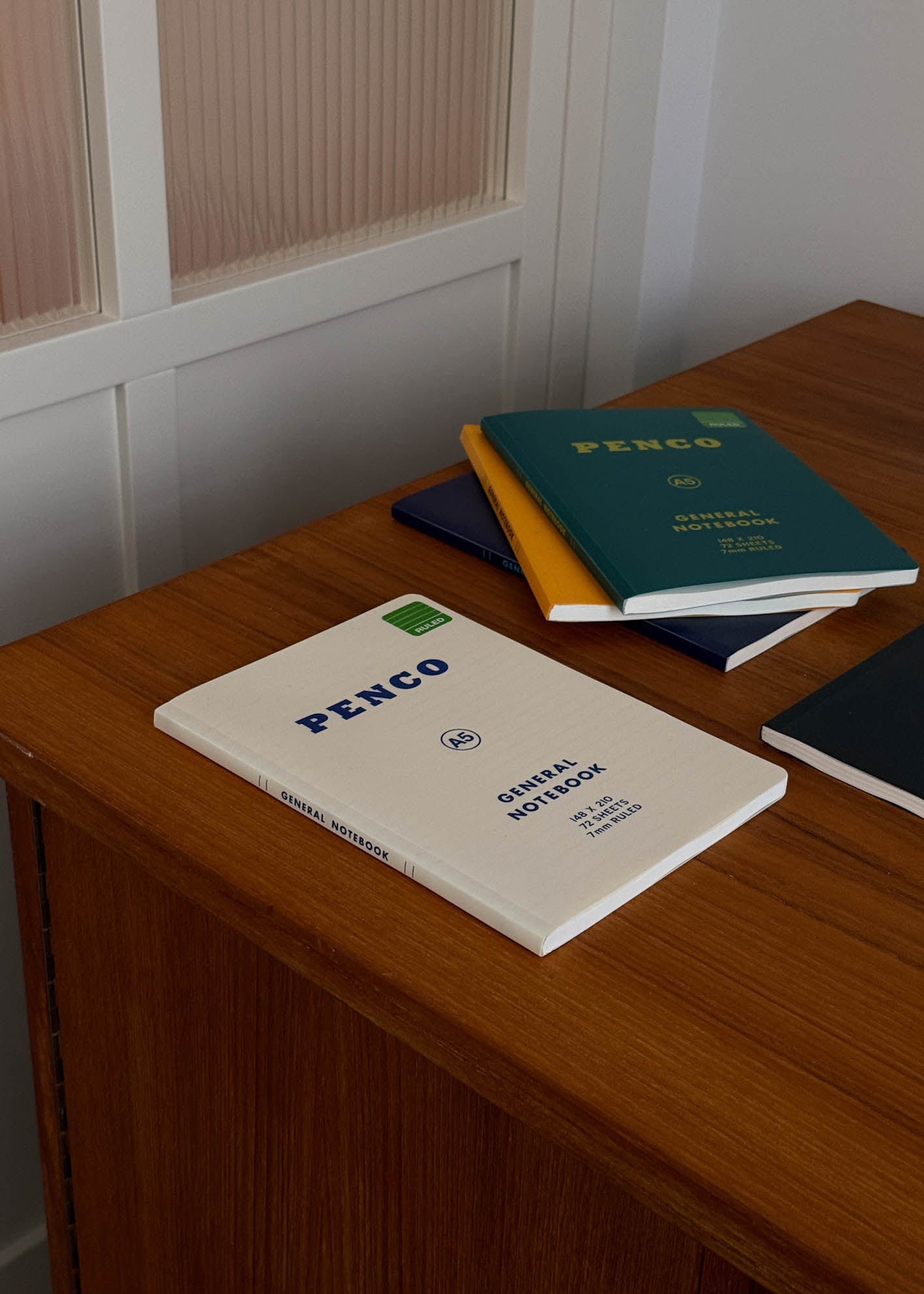 Penco A5 notebooks on a wooden surface with a neutral background