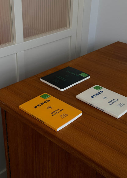 Three A6 size notebooks with 'PENCO' branding on a wooden surface.