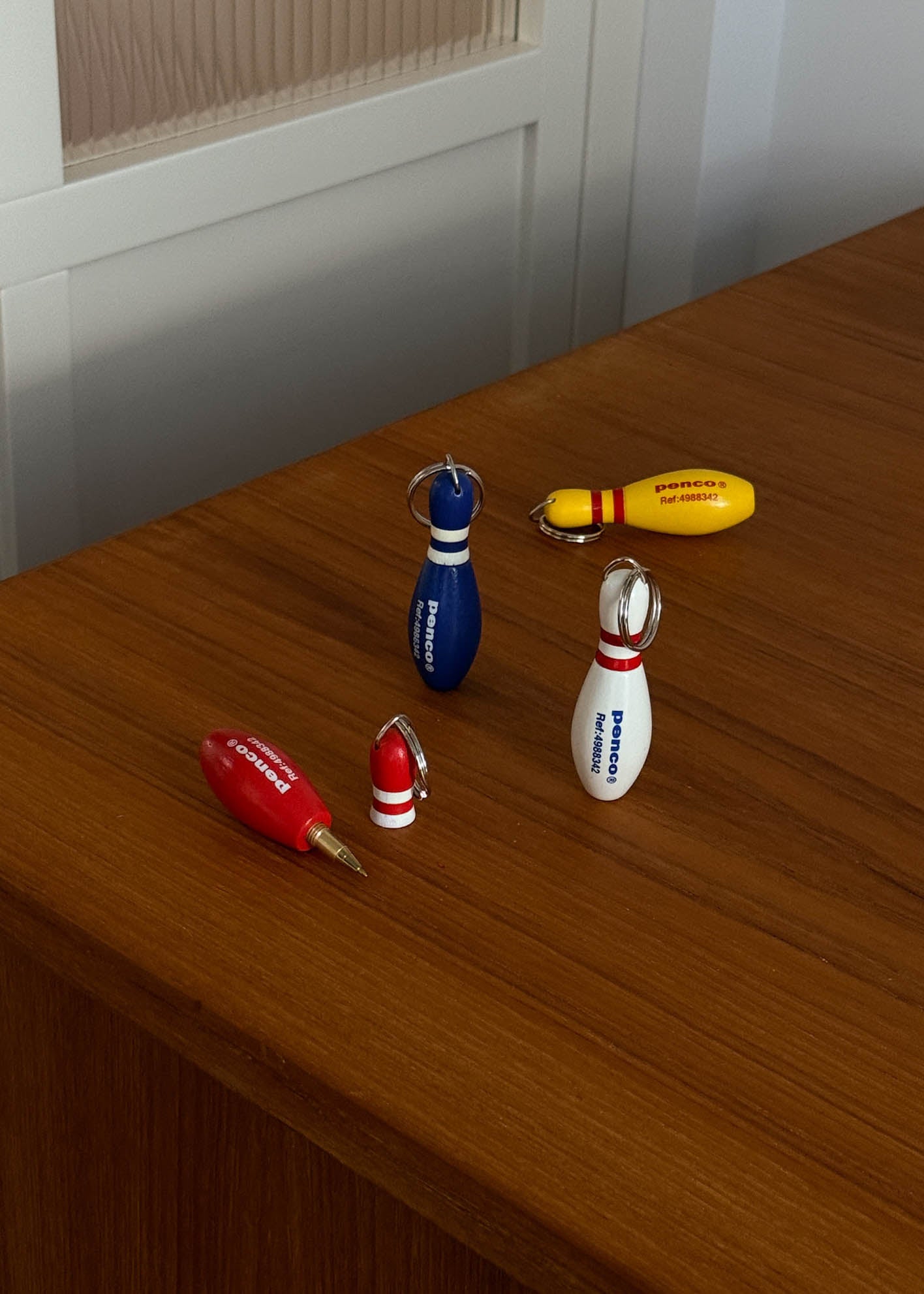Set of mini bowling pin key chains on a wooden surface